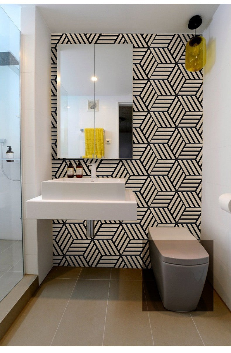 Modern bathroom with black and white geometric hexagon panel accent wall behind sleek sink and toilet.